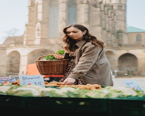 Person choosing fresh vegetables at a market